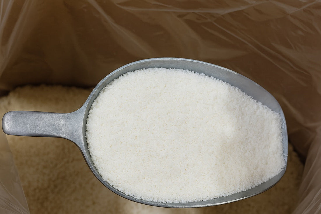  fine desiccated coconut in a metal scoop over a bulk container